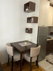 La cuisine est équipée d'une table, de chaises et d'un réfrigérateur. dans l'établissement Apartman Manja, à Lukavica