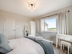 una camera da letto con un letto con uno specchio e una finestra di Manor Farm Cottage a Hornby