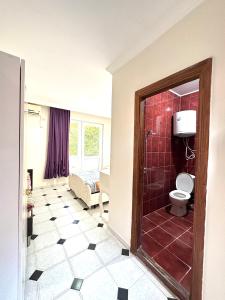 a bathroom with a shower and a toilet in a room at Tbiliselebi Hotel Ureki in Ureki