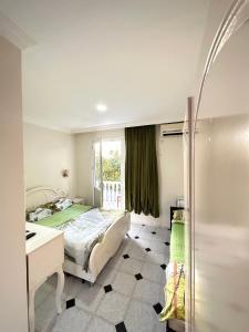 een slaapkamer met een bed, een bureau en een raam bij Hotel Tbiliselebi in Ureki