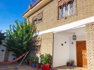 una casa con una hamaca delante en Preciosa casa grande con patio en Sevilla 8PAX en Sevilla