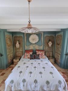 1 dormitorio con 1 cama grande y lámpara de araña en Villa Gloria en Landaul
