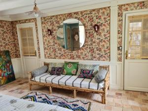 a living room with a couch and a mirror at Villa Gloria in Landaul