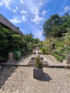 Landaul的住宿－Villa Gloria，砖砌庭院里种有盆栽植物的花园