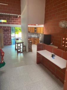 a large kitchen with a red brick wall at Villa Celeste in Arboletes