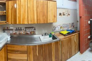 a kitchen with wooden cabinets and a sink at Villa Celeste in Arboletes