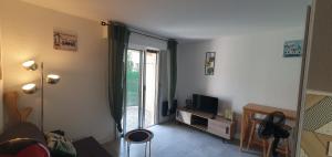 un salon avec une télévision et une fenêtre dans l'établissement Studio proche plage tout à pied, à Fréjus