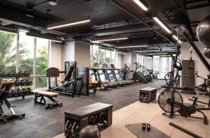 a gym with a lot of treadmills and machines at Miami Downtown Comfy Condo-Hotels in a luxury modern building in Miami