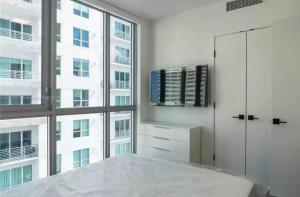 a white room with a large window and a table at Miami Downtown Comfy Condo-Hotels in a luxury modern building in Miami
