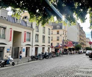 a group of motorcycles parked on the side of a street at Superbe Studio Montmartre, rue des Abbesses in Paris