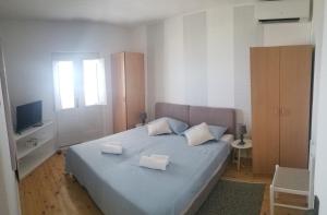 a bedroom with a blue bed with two white pillows at Apartmani KaLu in Mlini