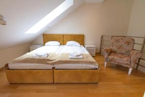 a bedroom with a large bed and a chair at Urban Suite Zlatibor in Zlatibor