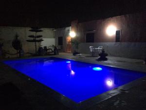 uma piscina à noite com iluminação azul em Chez Ali em Essaouira