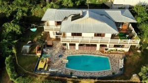 - une vue aérienne sur une maison avec une piscine dans l'établissement Villa Vaiana EURL Vaiana Faratea officedu tourisme 1593DTO MT, à Paopao