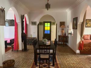 a dining room with a table and a bedroom at Chez Ali in Essaouira