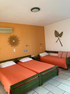 a room with two beds and a butterfly on the wall at Kapares Studios in Agia Anna Naxos