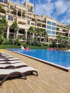 a hotel with a large swimming pool in front of a building at Argisht luxury apartment Golden sands in Golden Sands