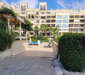 a large building with a patio in front of it at Argisht Luxury Apartment Golden Sands in Golden Sands