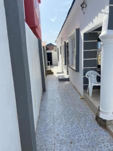 a walkway between two buildings with a bench on it at Rahims 3 Bed Bungalow - Dalaba in Jarbang