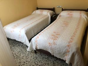 duas camas sentadas uma ao lado da outra num quarto em HOSTAL COSTA SOL em Castell de Ferro