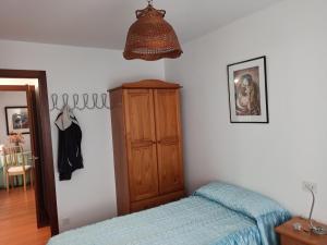 Schlafzimmer mit einem Bett und einem Holzschrank in der Unterkunft CANTALARRANA in Cangas