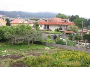 una casa con techo rojo en un pueblo en CANTALARRANA, en Cangas de Morrazo