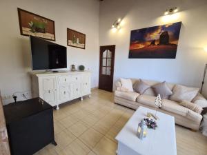 sala de estar con sofá y TV en Jazmín, en Arico Viejo