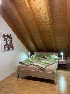 罗拉赫Ferienwohnung Zentral in Lörrach - KONUS Gästekarte inklusive的木天花板的客房内的一张床位