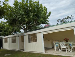 a garage with a table and chairs and a tree at Camping Mayer in Cavallino-Treporti