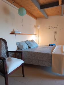 ein Schlafzimmer mit einem Bett und einem Stuhl in einem Zimmer in der Unterkunft Casa Garibaldi in Lucca