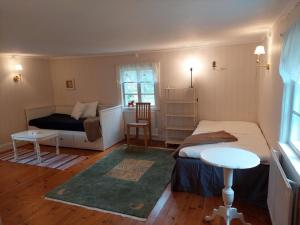 um pequeno quarto com uma cama e uma mesa em Trevligt eget hus med kakelugn i lantlig miljö em Vikingstad
