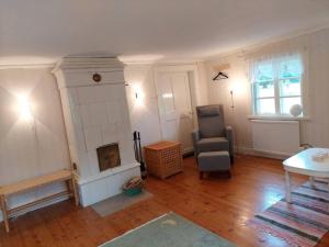 a living room with a chair and a fireplace at Trevligt eget hus med kakelugn i lantlig miljö in Vikingstad