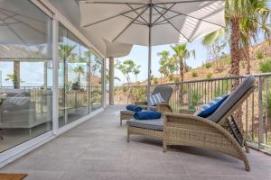 a porch with two chairs and an umbrella at Seaview Luxury 2 Bedrooms Apt in Reserva del Higueron in Benalmádena