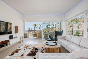 a living room with a white couch and a table at Seaview Luxury 2 Bedrooms Apt in Reserva del Higueron in Benalmádena