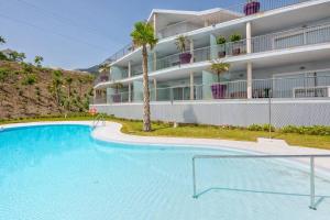 a large swimming pool in front of a building at Seaview Luxury 2 Bedrooms Apt in Reserva del Higueron in Benalmádena
