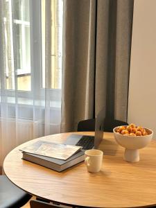 a table with a laptop and a bowl of fruit on it at Silver Apartment in Daugavpils