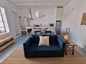 ein Wohnzimmer mit einem blauen Sofa und einer Küche in der Unterkunft Casa de Santa Margarida in Mourão