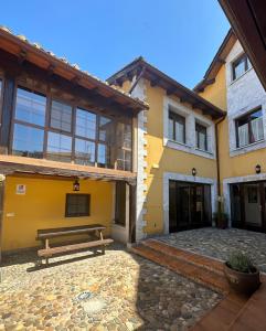 un banco en el patio de un edificio en Hotel rural Monasterio de Ara Mada en Santa Colomba de las Arrimadas