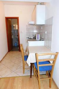 a kitchen and dining room with a table and chairs at Apartments Ljiljana in Brna +7 photos