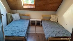 a small room with two beds and a table at Türkiz Apartman - 5 szobás 13 fős apartmanház 4km a Balaton- Balatonszabadi in Balatonszabadi