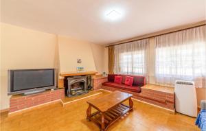 a living room with a fireplace and a tv at Nice Home In Reus With Outdoor Swimming Pool, Wifi And Swimming Pool in Reus
