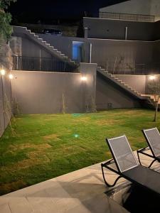 two chairs on a patio with a yard at night at İBAK Apartments in Gümüşlük