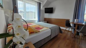 1 dormitorio con cama, mesa y ventana en Willa Wladek, en Władysławowo