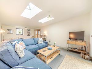 a living room with a blue couch and a tv at Number 29 in Alnwick