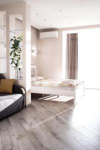 um quarto branco com uma cama e um sofá em VIP Квартира на Науковій, аквапарк em Lviv