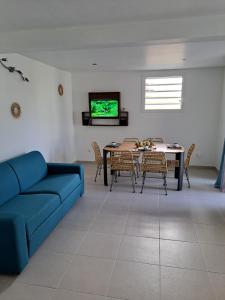 a living room with a blue couch and a table at la casa mangue in Le Diamant