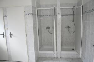 W łazience znajduje się prysznic ze szklanymi drzwiami. w obiekcie TJ Lokomotiva Mariánské Lázně w Mariańskich Łaźniach