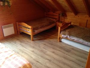 um quarto com 2 camas num chalé de madeira em Chalet Le Roncing em Gérardmer