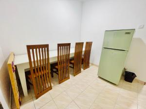 cocina con mesa, 4 sillas y nevera en The Colombo Home en Nugegoda