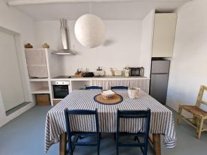 Una cocina con una mesa y sillas en una cocina. en Casa de Santa Margarida, en Mourão